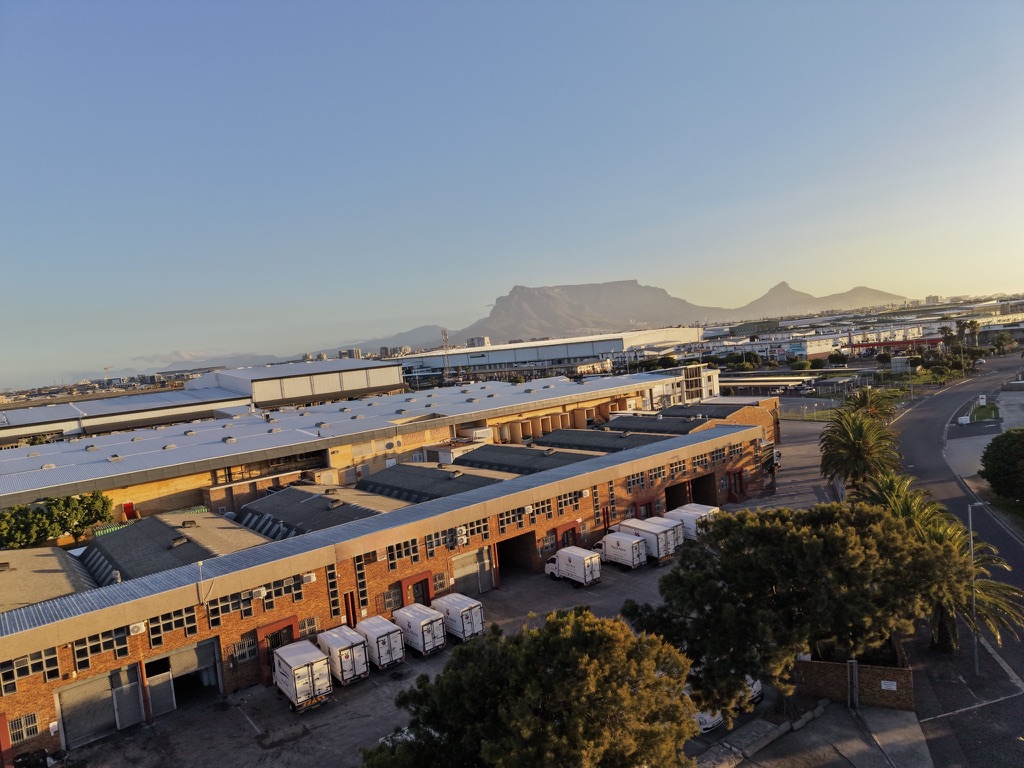 Aerial view of the Veg & More Montague Gardens warehouse with Table Mountain beyond